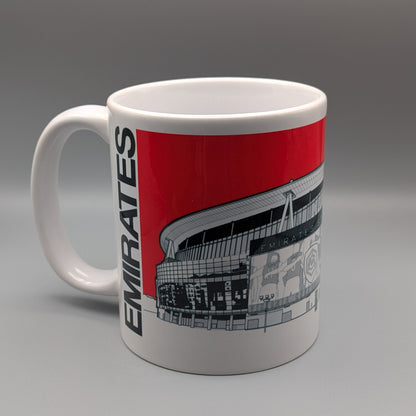 A white ceramic mug featuring a red and black graphic print of the Emirates Stadium, with the word 'EMIRATES' printed vertically in black on the side, set against a neutral gray background.